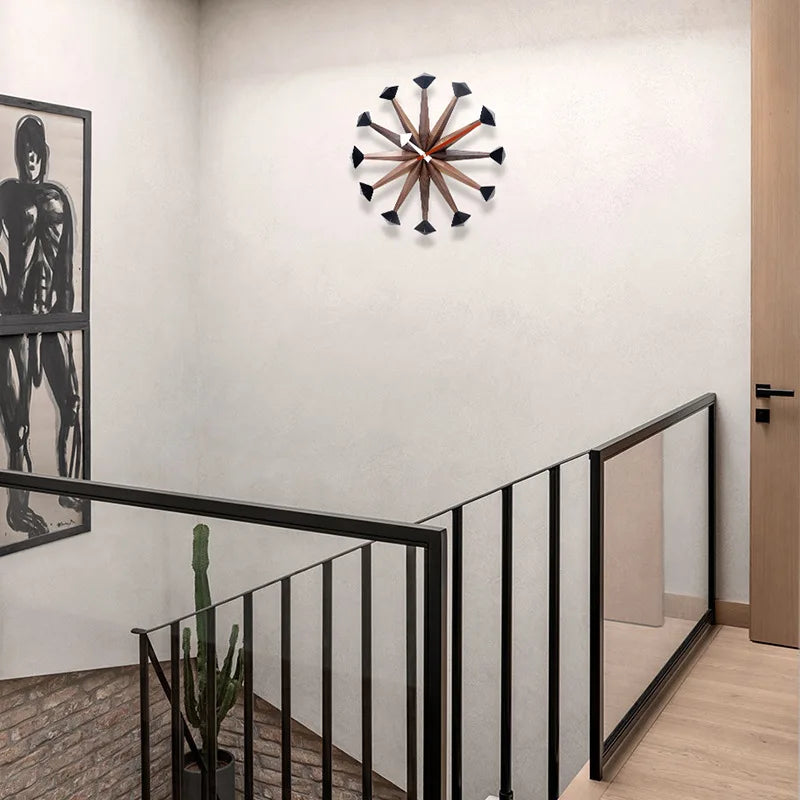 Decorative wall clocks modern - Drayen A stylish clock with wooden spokes and black tips, perfectly encapsulating mid-century modern design, enhancing this minimalist space with its bold geometric style.