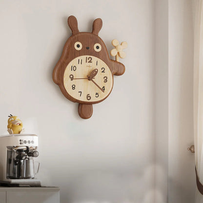 Veynor wall clock, a whimsical wooden bear-bunny hybrid with a pendulum tail, adds charm above a coffee machine topped with a yellow figurine, enhancing your space with natural beauty.