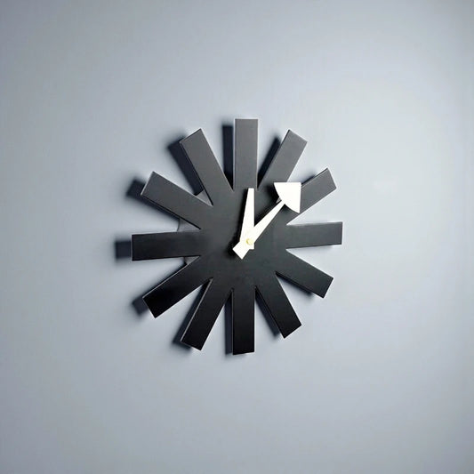 Black decorative wall clock with radiating metal spokes and minimalist face