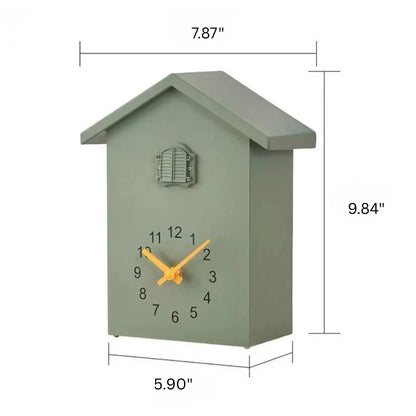 Wooden Cuckoo Clock - Brivon: A modern, house-shaped analog clock with a muted green finish, featuring yellow hands, a black-numbered dial, and a charming bird pendulum. Ideal for contemporary home decor.