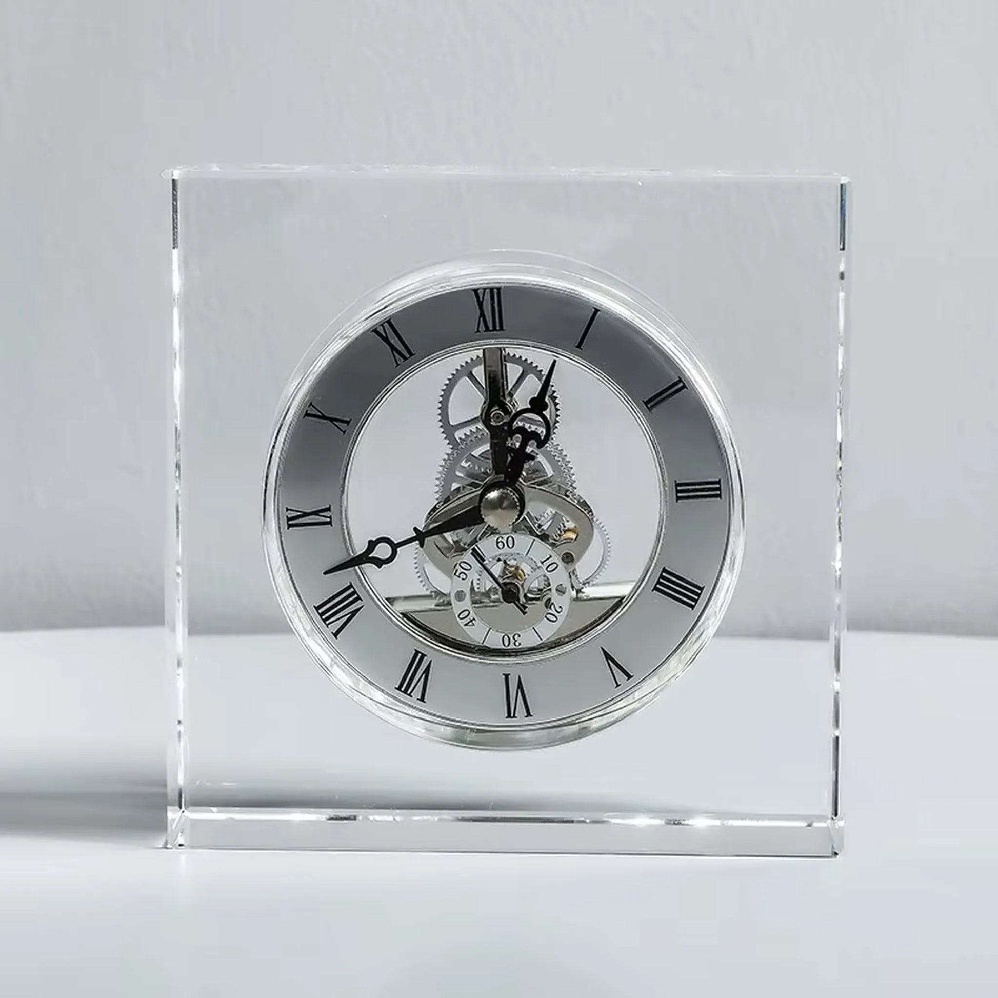 Crystal tabletop clock - Dunley: A minimalist desk clock encased in clear glass, showcasing exposed gears and a silver ring with black Roman numerals, perfect for modern elegance.