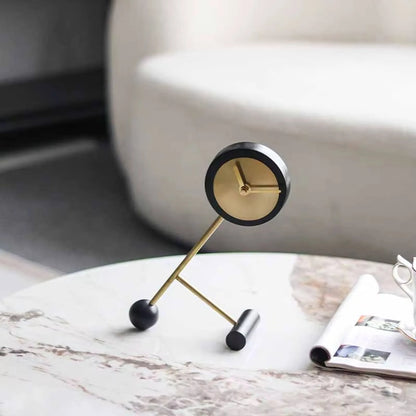 Metal Tabletop Clock - Winsley: A minimalist clock with a brass face and decorative gears, set on a marble-patterned table, supported by abstract brass rods, embodying industrial charm.