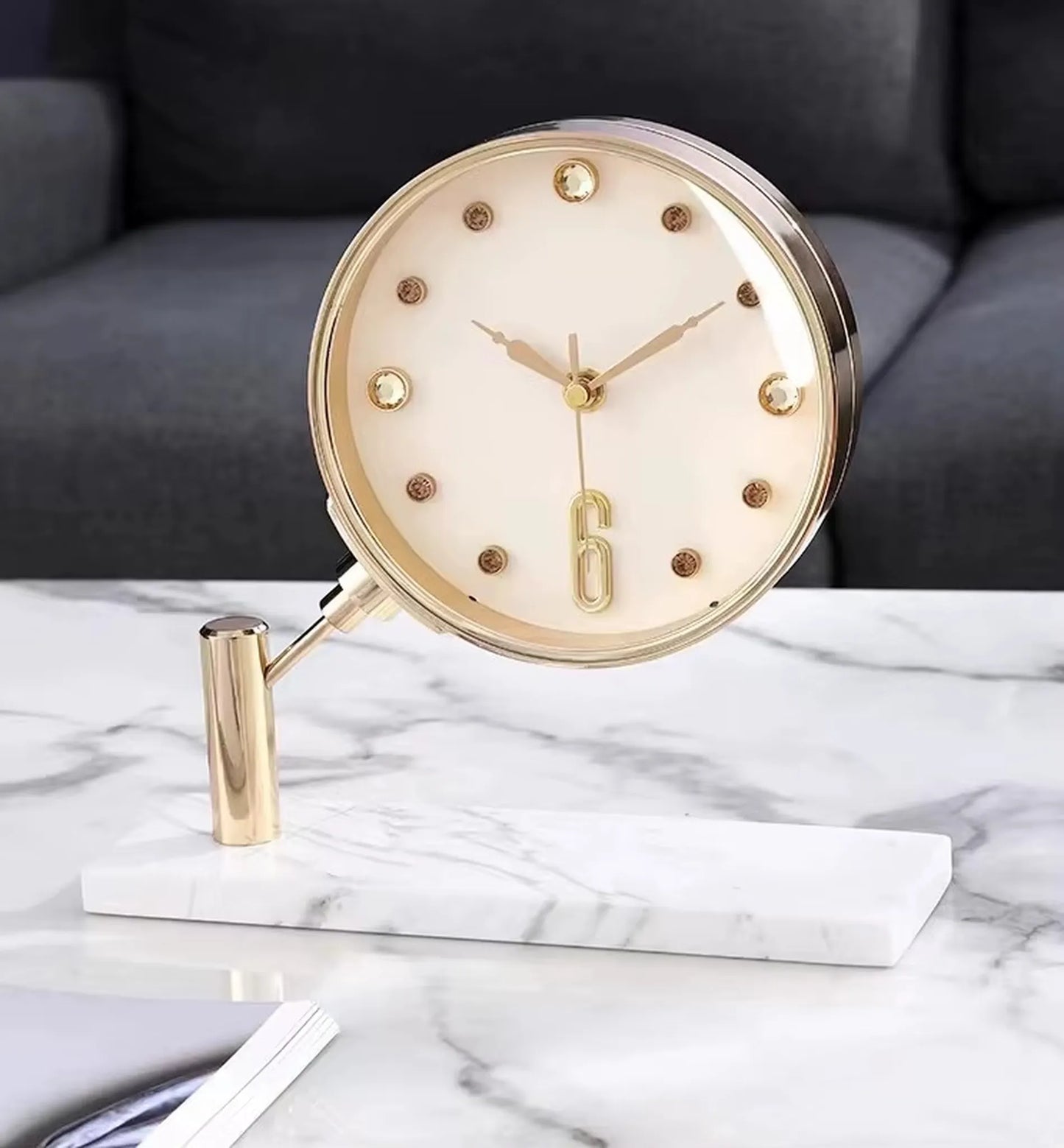 Luxury Table Clock - Corlen: A round-faced clock with gold-plated bezel and hands, mounted on an angled gold post atop a white marble base, perfect for modern decor.