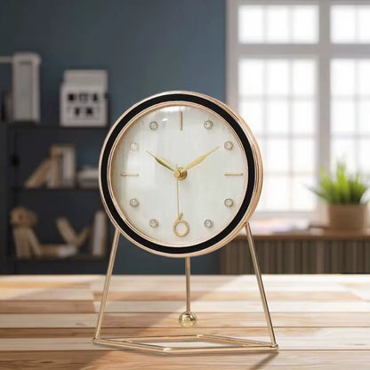Dralen Pendulum Table Clock: A minimalist round clock with gold-tone hands and geometric gold stand, featuring a rhythmic pendulum, perfect for adding elegance to any mantel or desk.