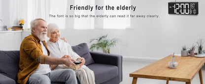 Elderly couple in a modern living room with the Large digital wall clock - Eldon, showcasing large LED numbers and temperature display, emphasizing readability and ease for seniors.