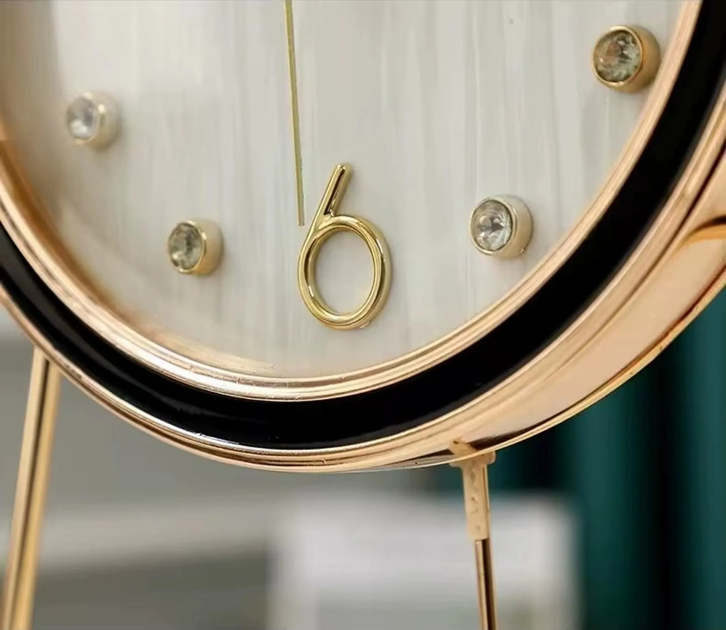 Dralen Pendulum Table Clock: Close-up of gold-plated numeral “6” and crystal markers, featuring a slender gold hand. Decorative modern design with gold bezel and visible support leg.
