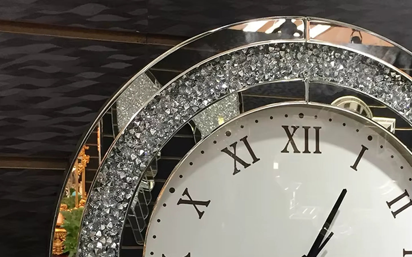 Fancy wall clock - Norwyn with a white Roman numeral face and black hands, encased in a mirrored frame adorned with sparkling crystals, designed to be an elegant focal point.