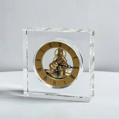 Crystal tabletop clock - Dunley: A clear acrylic desk clock featuring a gold skeleton face with Roman numerals, showcasing visible gears, offering a modern touch of elegance. Ideal for any desk or mantel.