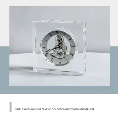 Crystal tabletop clock - Dunley features a clear-glass body showcasing its skeletonized movement, Roman numeral silver face, and ornate hands. A modern elegance piece for desks or mantels.