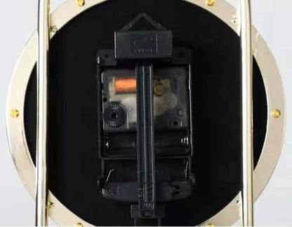 Back view of the Leiton Pendulum Table Clock, showcasing the black movement housing, orange stepper-motor coil, gear train adjustment wheel, AA battery holder, and decorative frame details.