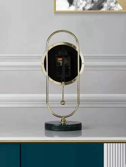Pendulum Table Clock - Leiton: A modern clock with exposed gears, gold-tone oval frame, hanging pendulum, and marble base, perfect for adding dynamic elegance to a mantel or desk.