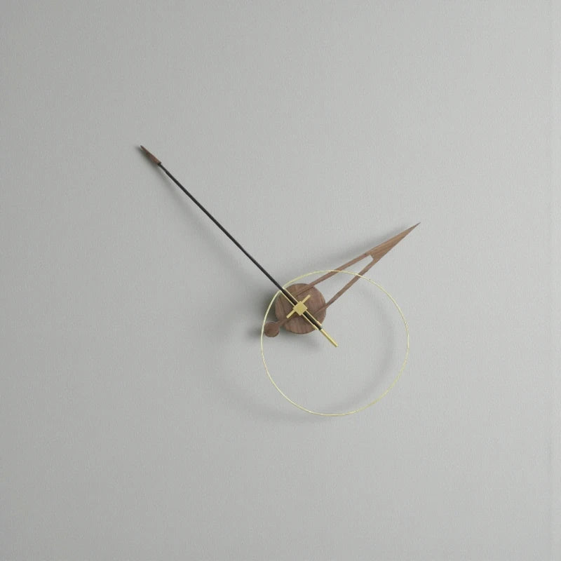 Unique modern wall clocks - Crawell features a minimalist design with a transparent brass ring, walnut and metal hands, and an exposed mechanism, creating a sculptural timepiece against a light-grey wall.