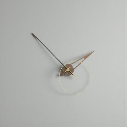 Unique modern wall clocks - Crawell features a minimalist design with a transparent brass ring, walnut and metal hands, and an exposed mechanism, creating a sculptural timepiece against a light-grey wall.