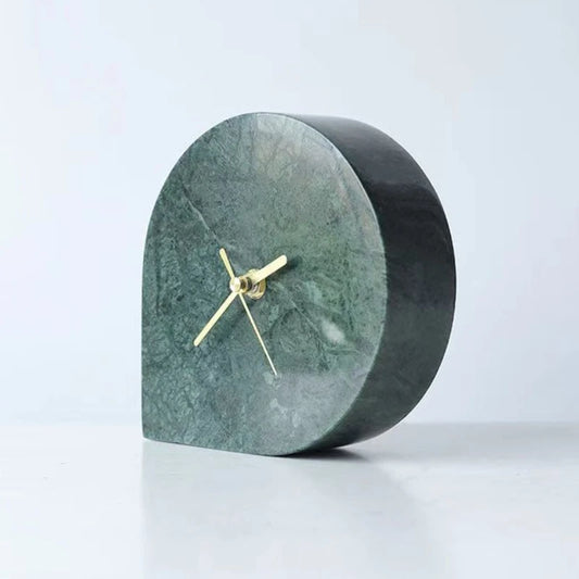 Marble mantel clock with half-moon arch design and gold hands on white surface