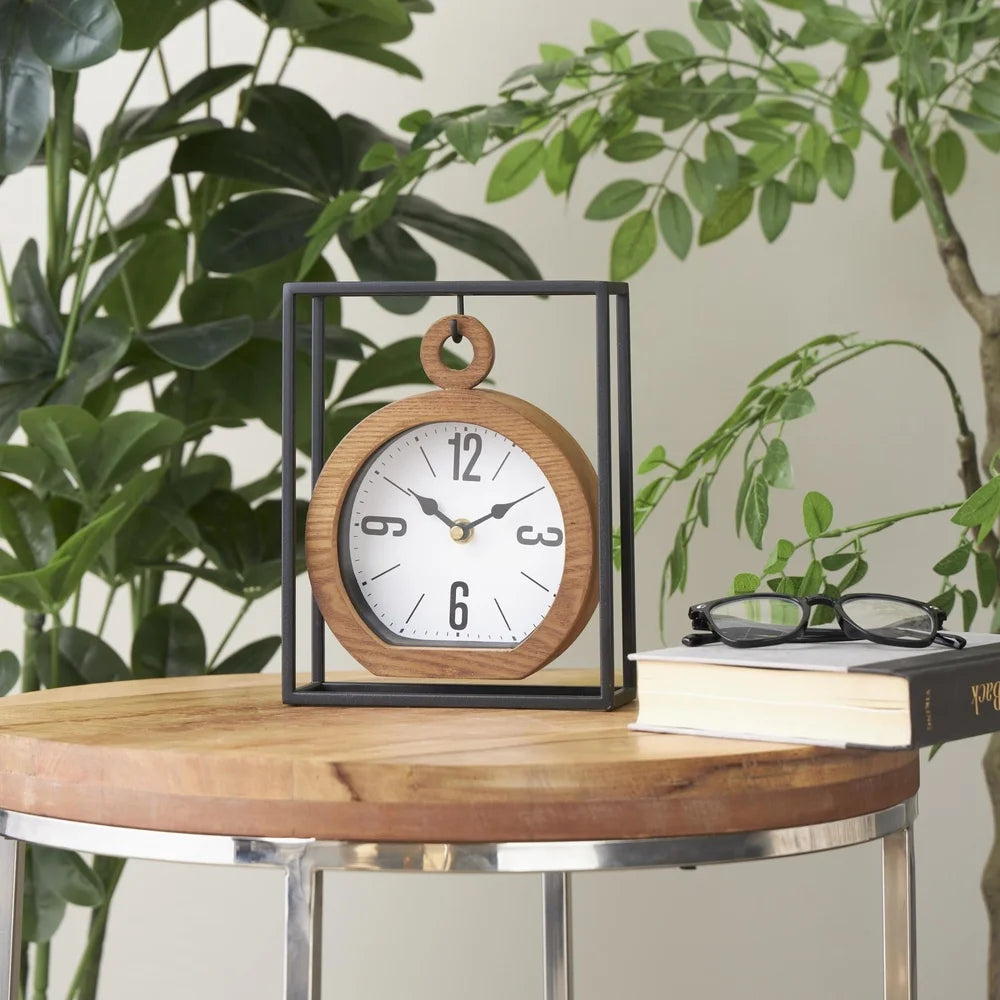 Suspended Clock - Jarwin: A round-face analog clock with a wooden bezel, suspended in a black metal cube frame, elegantly displayed on a wooden table next to books and greenery.