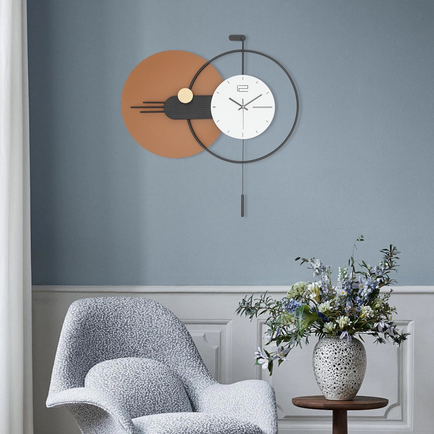 Big Wall Clock Modern - Darrington, a geometric pendulum clock with overlapping circles, complements a light-gray lounge chair and wooden side table, creating a chic seating nook.