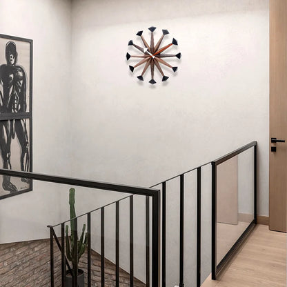 Decorative wall clocks modern - Drayen A stylish clock with wooden spokes and black tips, perfectly encapsulating mid-century modern design, enhancing this minimalist space with its bold geometric style.