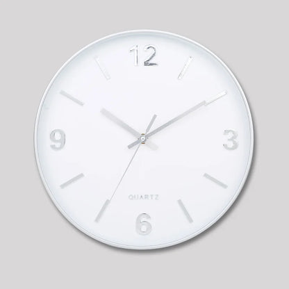 Modern Silent Wall Clock - Densford with a white face, silver hands, and raised metallic numerals at 12, 3, 6, and 9. Features a silent, non-ticking quartz movement for contemporary elegance.