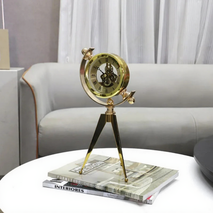 Vintage Table Clock - Gorven: A brass-tone tripod clock with visible gears atop stacked design magazines on a white coffee table, adding vintage charm and functionality to any room.