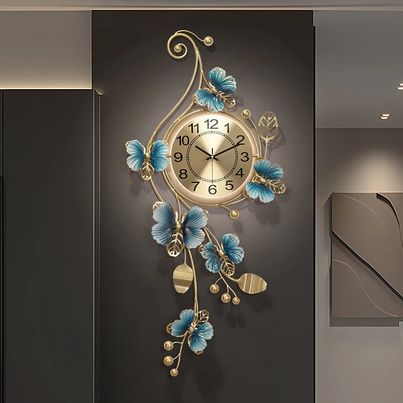 Hanging Wall Clock - Elmsford features a round gold-toned face with black numerals, encased in ornate metal vines and blue flowers, making it a contemporary art piece for your wall.