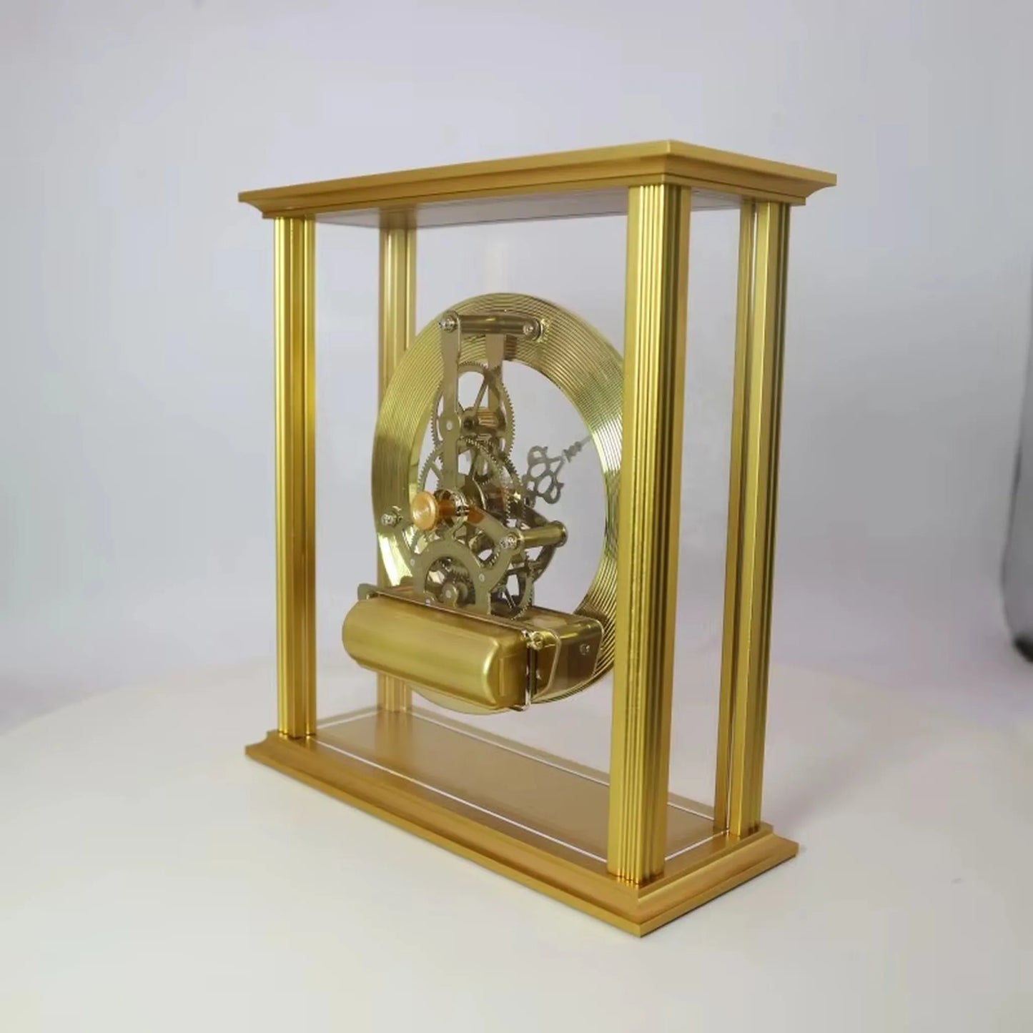 Brass table clock - Braven in a clear gold-colored case showcasing an intricate skeleton-style mechanism with visible brass gears and a coiled mainspring, offering timeless sophistication for any desk or mantel.