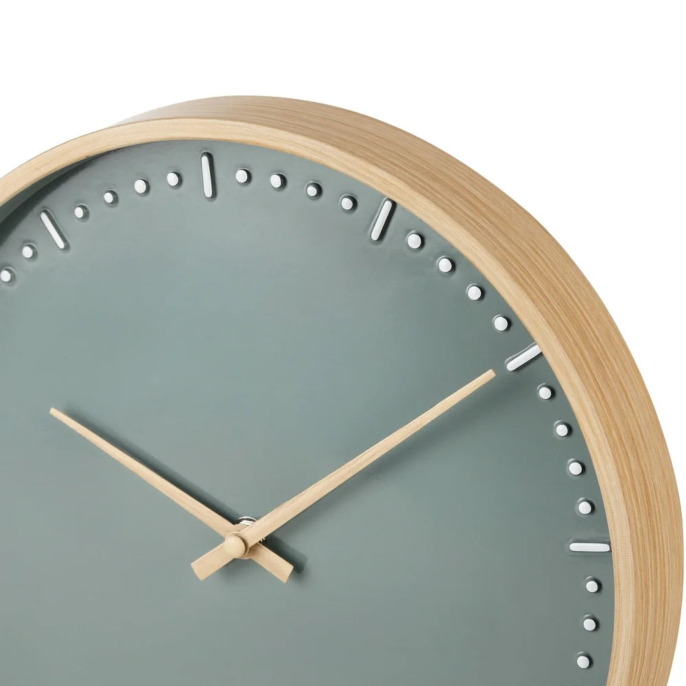 Small modern wall clock - Merrin, featuring a slim wooden frame and a minimalist muted green face with embossed hour markers and wooden hands, designed to add Nordic elegance to any room.