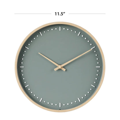 Small modern wall clock - Merrin features a minimalist design with a light wood frame and muted blue-green face. White inset markers and wood-tone hands deliver subtle elegance, ideal for any room.