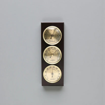 Weather Station Wall Clock - Harlton: A wall-mounted unit featuring an analog thermometer, barometer, and hygrometer set in dark wood with brass-rimmed dials, offering a sophisticated touch for time and environmental monitoring.