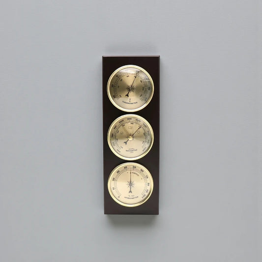 Weather Station Wall Clock - Harlton: A wall-mounted unit featuring an analog thermometer, barometer, and hygrometer set in dark wood with brass-rimmed dials, offering a sophisticated touch for time and environmental monitoring.