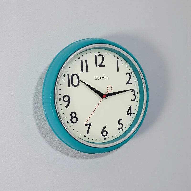 Blue metal Wall Clock - Farlton by Westclox with a teal frame and white face, featuring bold black numerals and hands. The clock shows 10:10 with a red second hand, enhancing any contemporary space.