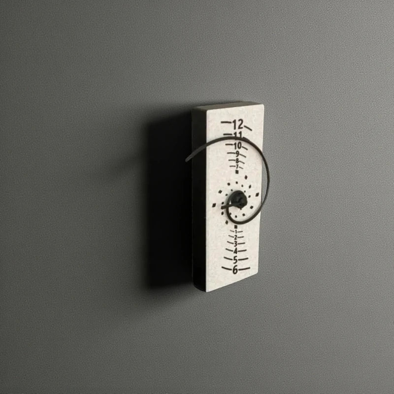 Fibonacci Wall Clock - Morston: A minimalist wall clock featuring a light-colored block with a numeric scale and a black spiral design, inspired by the golden ratio, showcasing art and mathematics.