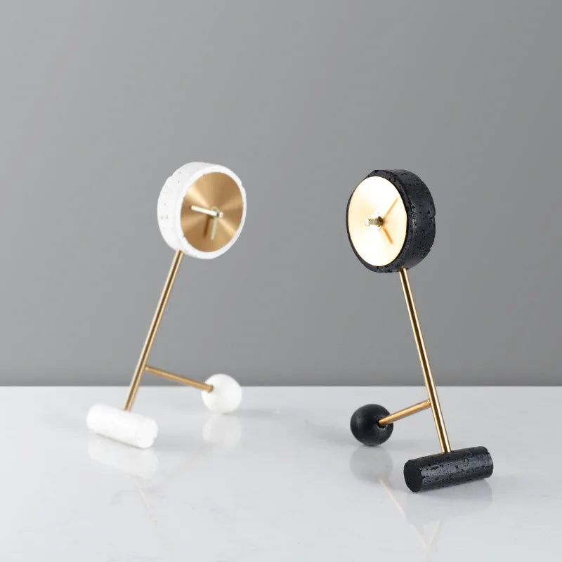 Metal Tabletop Clock - Winsley features an open-face design with decorative gears, gold-tone dial, and hands, set on angled gold rods. Includes white and black versions with minimalist cylindrical feet.