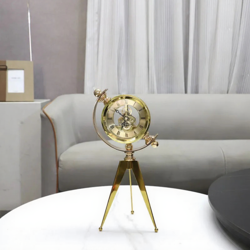Vintage Table Clock - Gorven: A brass-toned skeleton-style clock on a tripod stand, featuring Roman numerals. A unique blend of function and vintage charm, ideal for enhancing any mantel or desk.