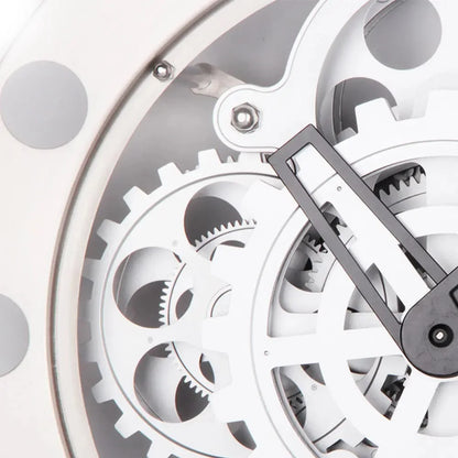 Modern Wall Clock Design - Elverton showcases exposed white gears interlocking beneath a clear cover, with a black hand visible, embodying a skeleton-style aesthetic with bold Roman markers and gun-metal trim.