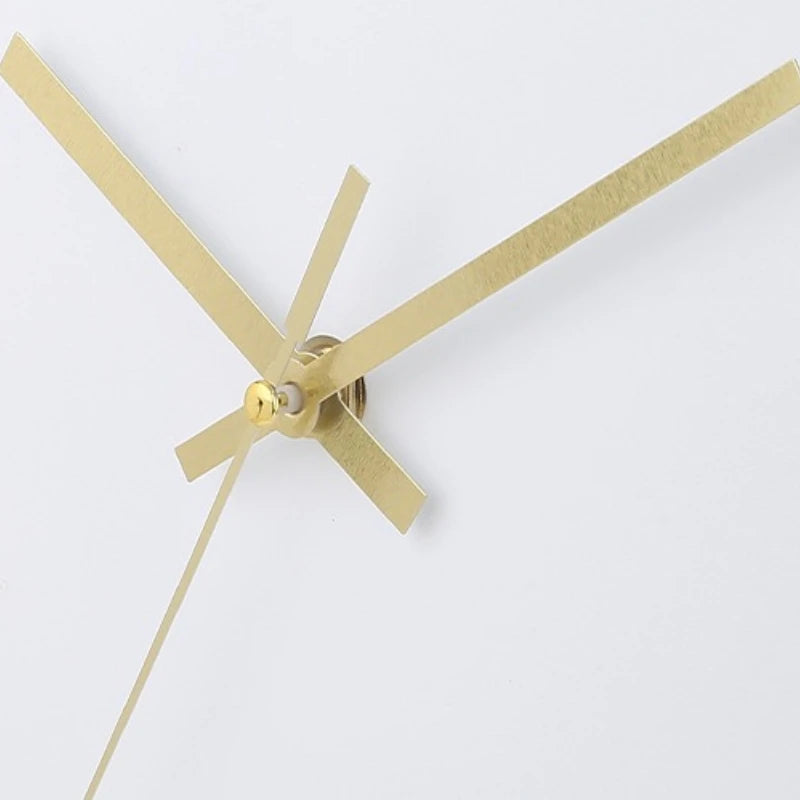 Modern Silent Wall Clock - Densford: Close-up of a minimalist clock mechanism with gold-tone hands against a white background, showcasing clean lines and silent quartz movement for contemporary elegance.