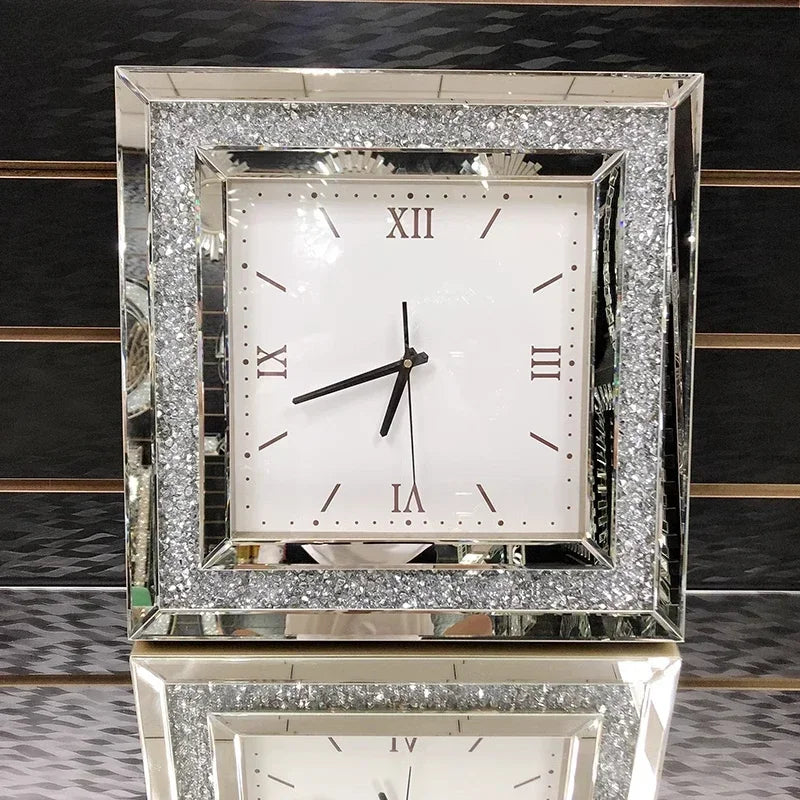 Fancy wall clock - Norwyn features a mirrored frame with crushed glass accents, a white face with minimalist hour markers, and Roman numerals, embodying elegance and serving as a striking room centerpiece.