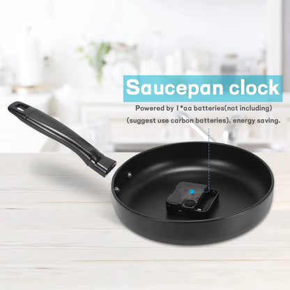 Frying Pan Wall Clock - Ashford: A whimsical clock set in a black nonstick frying pan with a fried egg design and utensil-shaped hands, ideal for adding culinary charm to any kitchen.