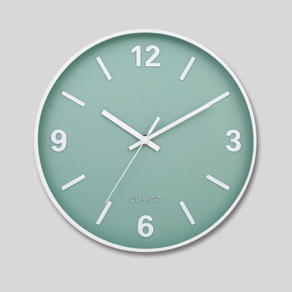 Modern Silent Wall Clock - Densford: This round wall-mounted clock features a mint-green face, white hands, numeral markers, and a sleek white frame, embodying contemporary elegance with its silent quartz movement.