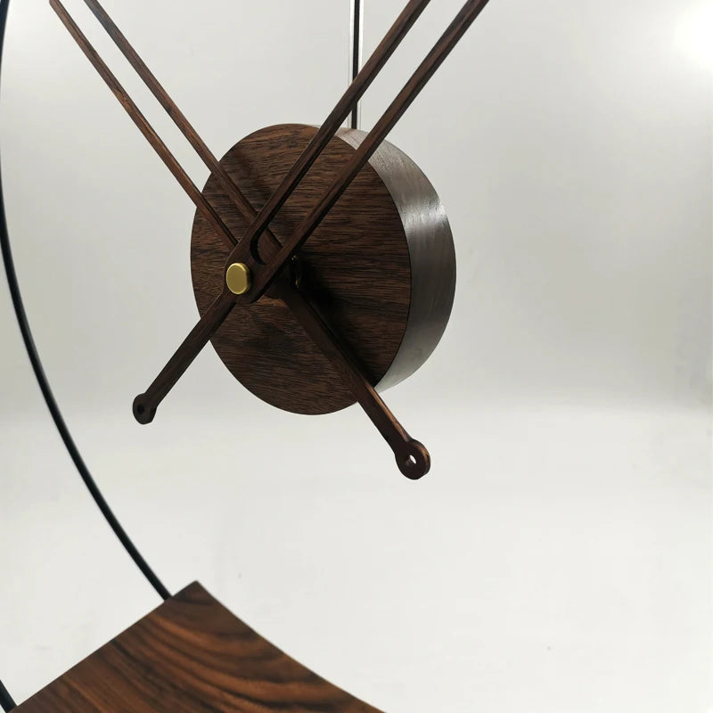 Design table clock - Bexley: A minimalist table clock featuring a round wooden housing with four slender wooden hands, centered on a brass pivot, encased in a sleek black metal frame.