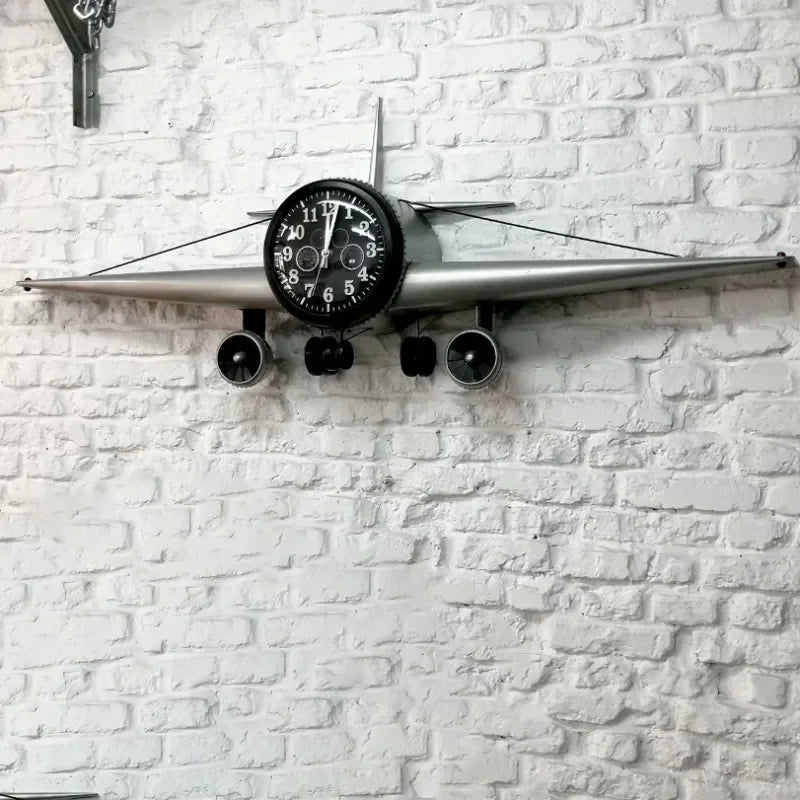 Close-up of airplane clock's black dial face with white numerals and detailed engines