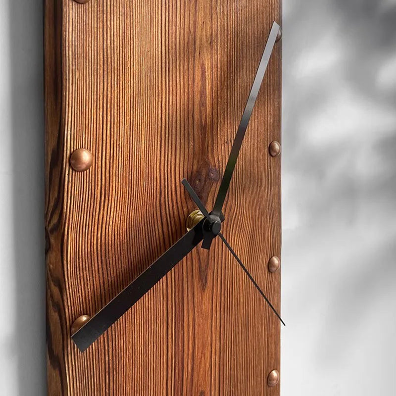 Wood Wall Clock - Stalford: A minimalist, industrial-style clock on a vertical linden wood plank with visible grain, copper-toned rivets, and slim black hands, perfect for large spaces.