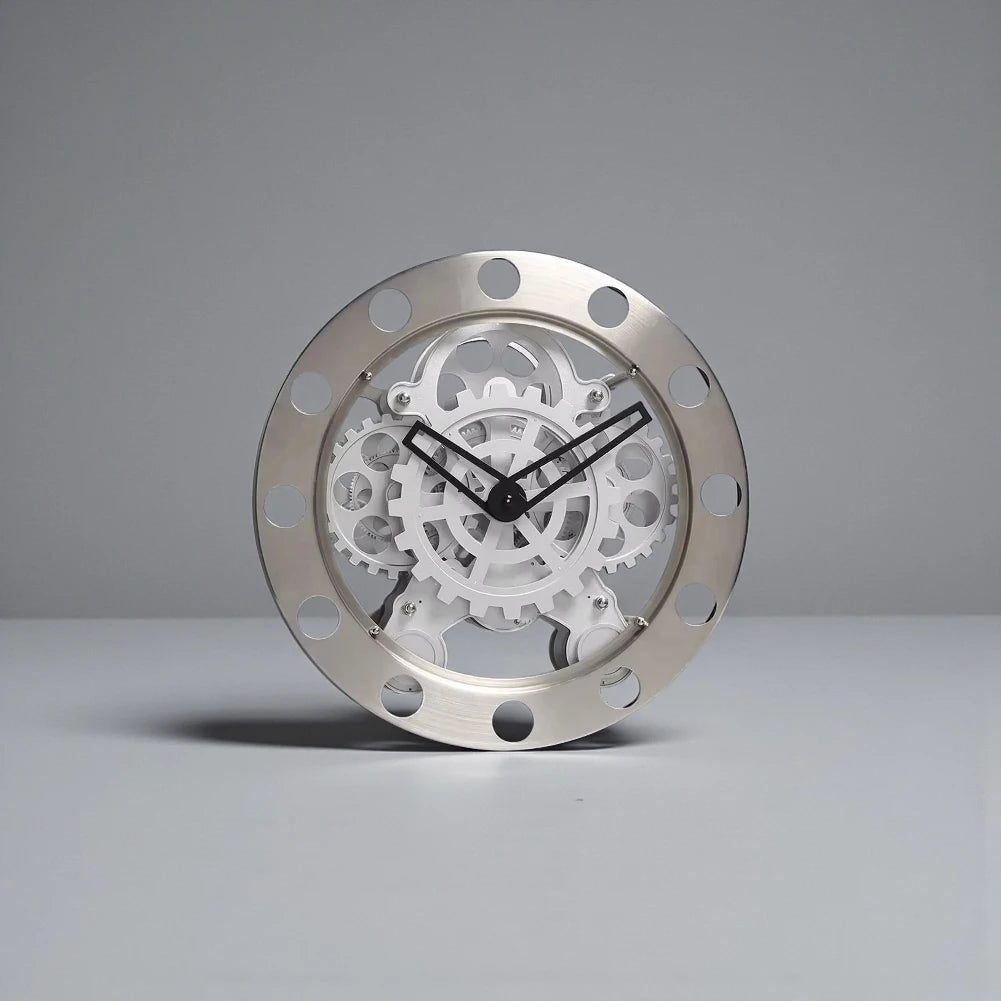 Modern Wall Clock Design - Elverton: This clock features a brushed-metal outer ring with cut-outs, showcasing exposed white gears and slim black hands, embodying a sleek mechanical aesthetic.