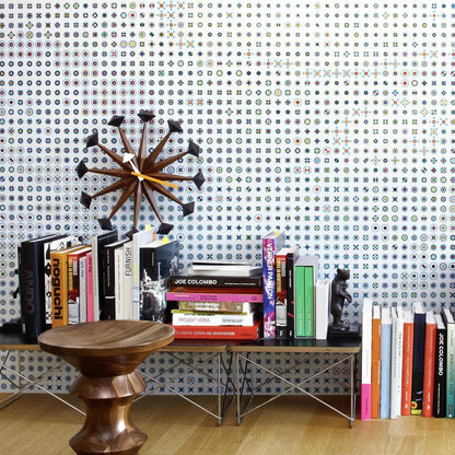 Decorative wall clocks modern - Drayen, featuring a mid-century design with wooden spokes and black tips, prominently displayed above a shelf filled with design books