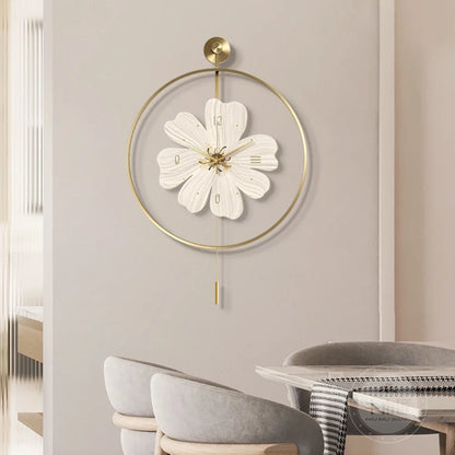 Flower wall clock - Fenton: A white floral-inspired clock with brass accents, elegantly suspended in a brass-colored hoop, adding a modern touch to the minimalist setting with neutral tones.