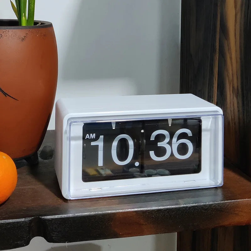 Vintage flip clock - TimeFlip: A small white flip clock displaying AM 10:36 on a dark wooden shelf, capturing retro elegance with its 24-hour display.