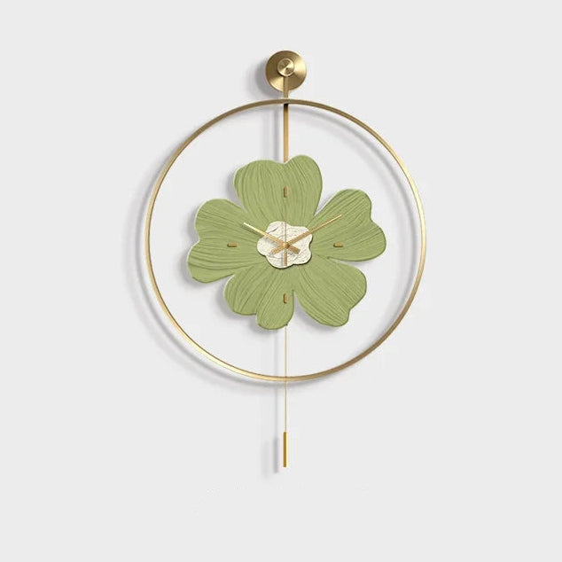 Flower wall clock - Fenton features a gold/brass frame with a muted green, flower-shaped face, gold hands, and a pendulum, embodying minimalist elegance and springtime charm from The Horologista.