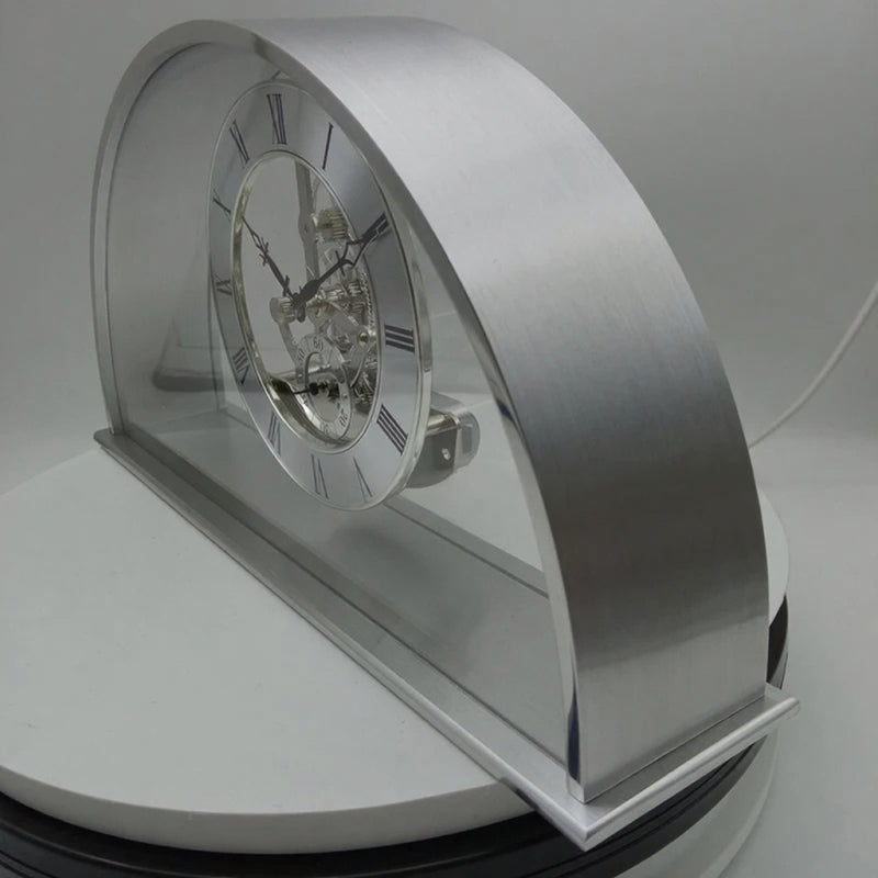 Crystal table clock - Cranley: A modern skeleton desk clock with a transparent face and Roman numerals, showcasing intricate chrome gears within a curved arch frame, set on a sleek rectangular base.