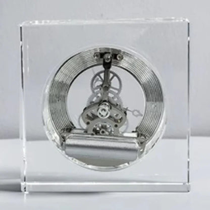 Crystal tabletop clock - Dunley: Showcasing a watch movement encased in clear acrylic, featuring a visible mainspring, gear train, and escapement, offering a sleek, modern touch to any desk or mantel.