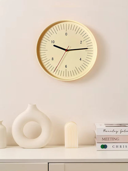 Numbers wall clock - Dunmore with a minimalist cream face and bold even numbers, featuring black hour and minute hands, and a red second hand, complemented by modern decor on a white shelf.