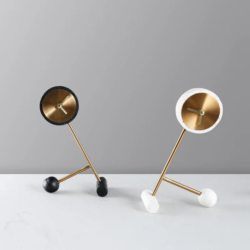 Metal Tabletop Clock - Winsley: A minimalist clock with a gold face atop a brass rod, supported by black and white concrete weights. Ideal for adding industrial charm to your desk or mantel.